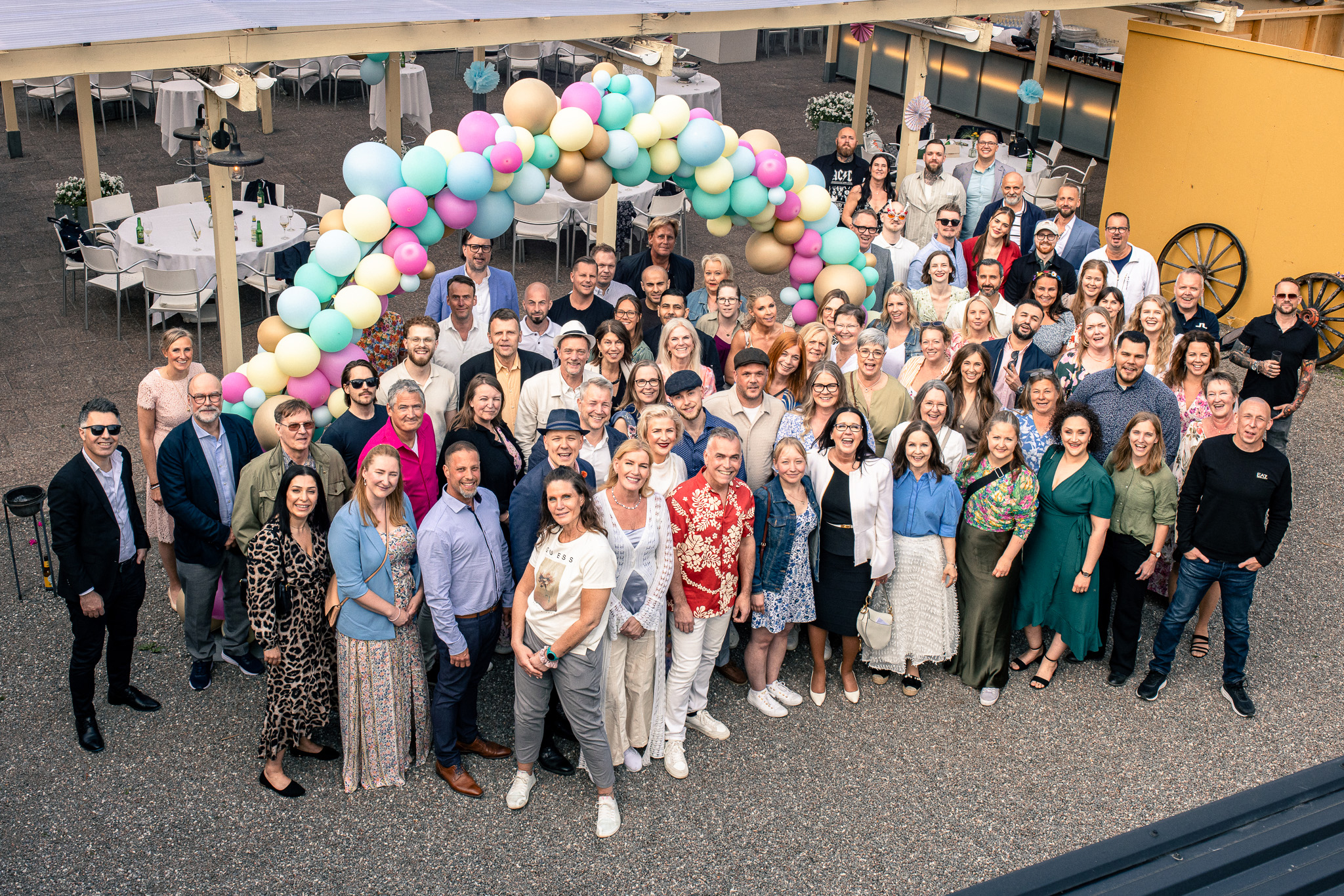 En stor grupp människor stående tillsammans med ballonger i bakgrunden.