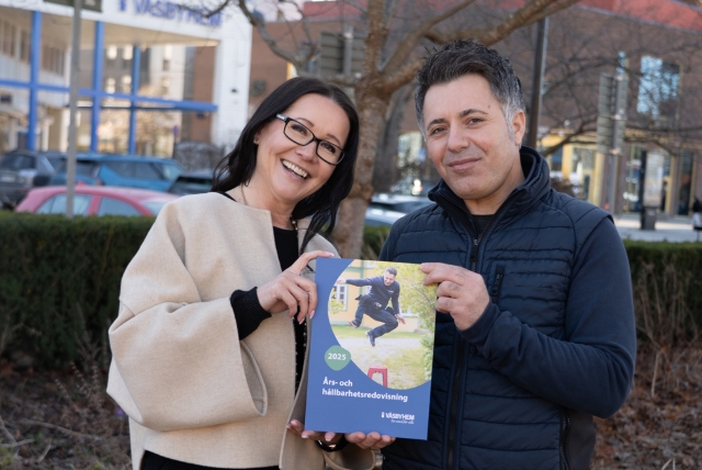 Två personer håller i en års- och hållbarhetsredovisning